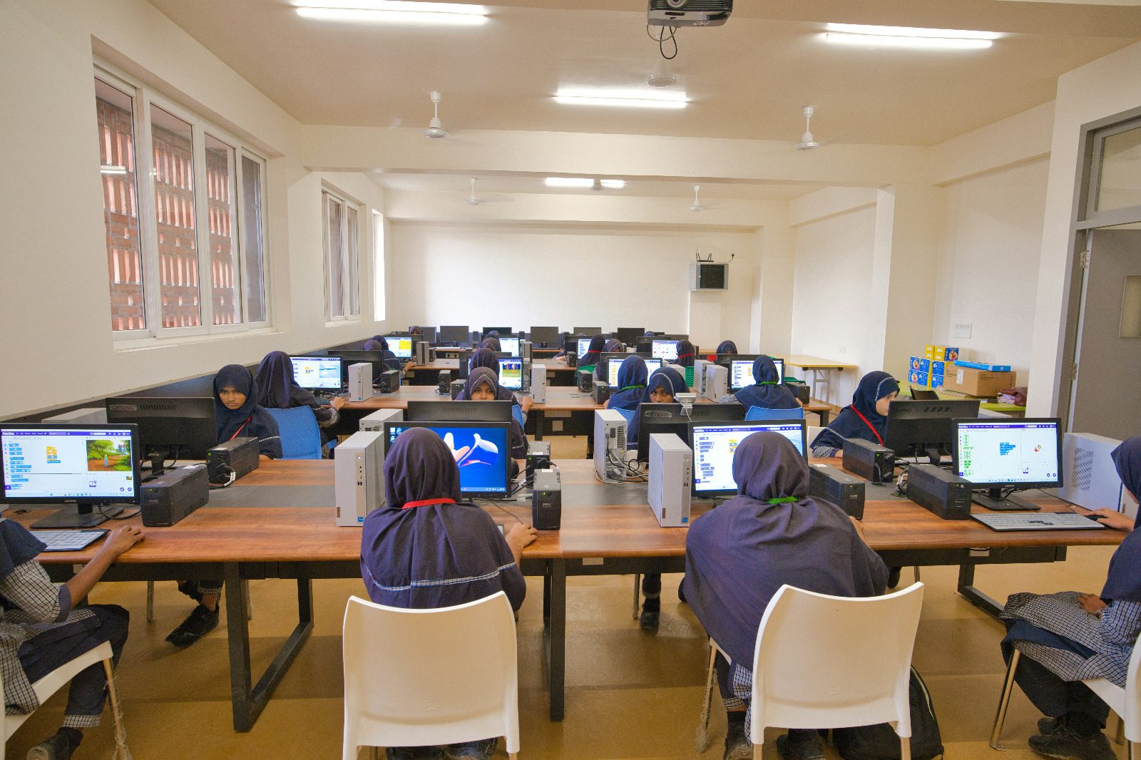 Placeholder photo: students working at desktop computers during a coding lesson