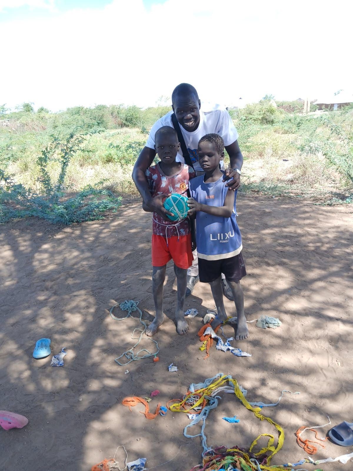 Placeholder photo: a coach with two young footballers holding a ball